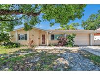 Charming single-story home featuring a cozy front porch and a well-maintained lawn with mature landscaping at 4025 Stratfield Dr, New Port Richey, FL 34652