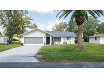 Charming single-story home with a well-maintained lawn, mature trees, and an attached two-car garage at 5309 Bayonne Ave, Spring Hill, FL 34608