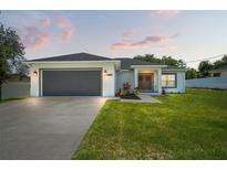 Charming home with a well-manicured lawn, gray garage door, and inviting entryway featuring decorative wreaths at 5328 Baldock Ave, Spring Hill, FL 34608