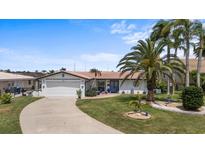 Charming single-story home with mature palms, a two-car garage, and well-maintained landscaping at 5340 Pilots Pl, New Port Richey, FL 34652