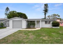Charming single-story home featuring a well-maintained lawn and an attached garage at 7735 Farmlawn Dr, Port Richey, FL 34668