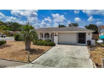 Charming one-story home featuring a driveway, garage, well-manicured lawn and lovely landscaping at 7736 Gaston Dr, Port Richey, FL 34668
