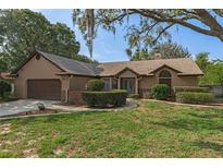 Charming single-story home with a well-manicured lawn and mature landscaping providing great curb appeal at 8402 Lake Hill Ct, Spring Hill, FL 34608