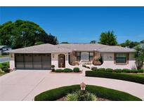 Charming single-story home featuring a well-manicured front yard and attached two-car garage at 10111 Glen Moor Ln, Port Richey, FL 34668