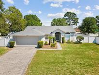 Charming single-story home featuring a well-maintained lawn, manicured shrubbery, and a welcoming two-car garage at 11192 Archer Ave, Spring Hill, FL 34608