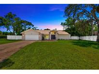 Charming single-story home featuring a manicured lawn, brick accents, and a two-car garage at 11291 Countrywood Ct, Spring Hill, FL 34609