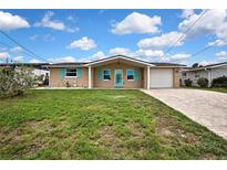 Charming single-story home featuring a brick facade, turquoise shutters, and a well-maintained front yard at 12637 2Nd Isle, Hudson, FL 34667
