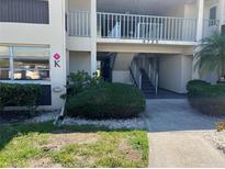 Condominium exterior featuring an elevated entry, stairs, and well-maintained landscaping at 4726 Marine Pkwy # 104, New Port Richey, FL 34652