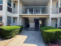 A well maintained two-story condominium with tidy landscaping and a walkway entrance at 4854 Marine Pkwy # 103, New Port Richey, FL 34652