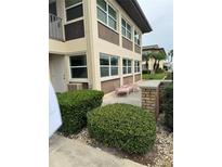 Condo exterior with beige and brown siding, trimmed windows and landscaping at 5111 Amulet Dr # 102, New Port Richey, FL 34652