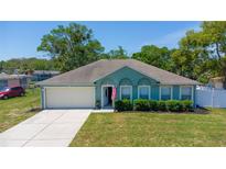 Charming single-story home featuring a well-maintained lawn, attached garage, and a welcoming entryway at 6172 Raleigh St, Spring Hill, FL 34606