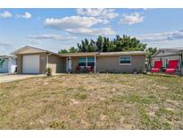 Charming single-story home with a brick facade, front lawn, and attached one car garage at 7830 Ilex Dr, Port Richey, FL 34668