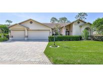 Charming single-story home with a well-manicured lawn, beautiful pavers, and a two-car garage at 8132 Summersong Ct, Spring Hill, FL 34606