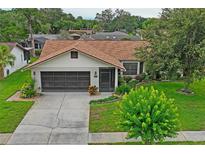 Charming single-story home with brick accents, mature landscaping, and a two-car garage at 8700 Wind Mill Dr, New Port Richey, FL 34655