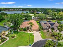 Stunning aerial view of home with lush landscaping, tile roof, and lake views in a desirable community at 9161 Southern Comfort Ct, Weeki Wachee, FL 34613