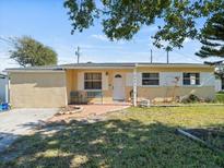 Charming single-story home featuring a well-maintained lawn and quaint front porch area at 9891 52Nd N St, Pinellas Park, FL 33782