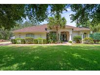 Charming home featuring lush landscaping, a well-maintained lawn, and a welcoming entrance at 12403 Moneta Rd, Weeki Wachee, FL 34614