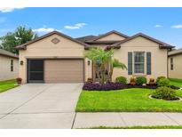 Charming single-story home featuring a well-manicured lawn, neutral paint, and an attached two-car garage at 1987 Trillium Blvd, Brooksville, FL 34604