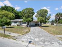 Charming single-story home with a spacious driveway and well-established trees in the front yard at 5154 Allamanda Dr, New Port Richey, FL 34652