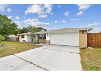 Charming single-story home with a manicured lawn, two-car garage, and welcoming front porch at 5642 Dove Dr, New Port Richey, FL 34652