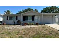 Charming single-story home featuring a well-manicured lawn and attached garage at 6406 Stone Rd, Port Richey, FL 34668