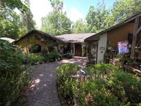 Charming home featuring a brick walkway through lush landscaping and decorative accents at 7323 Ray Browning Rd, Brooksville, FL 34601