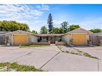 Charming single-story home featuring dual garage doors and a well-maintained front yard under a bright, sunny sky at 8634 Roble Way, Port Richey, FL 34668