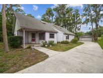Charming single-story home with a long driveway, detached garage, and mature trees creating a peaceful setting at 8755 Marigold Dr, New Port Richey, FL 34654