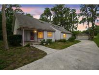 Charming single-story home with a long driveway, detached garage, and mature trees creating a peaceful setting at 8755 Marigold Dr, New Port Richey, FL 34654