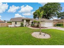 Beautiful single-story home with a manicured lawn, mature landscaping, and a spacious driveway at 8850 March Ct, New Port Richey, FL 34655