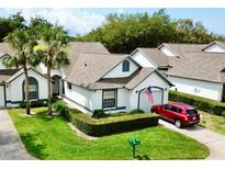 Charming single-story home with manicured lawn, trimmed hedges, and a red car parked in the driveway at 9200 Turnberry Ct, New Port Richey, FL 34655