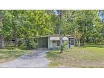 Charming home features a cozy front porch, carport, and well-maintained lawn at 9401 Bourbon St, New Port Richey, FL 34654