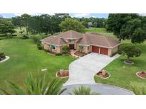 Beautiful home with manicured lawn, lush landscaping and concrete driveway leading to a spacious two-car garage at 10044 Twelve Oaks Ct, Weeki Wachee, FL 34613