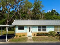 Charming single-story home with a light blue exterior, cozy front yard, and covered parking, creating a welcoming curb appeal at 11733 Bayonet Ln, New Port Richey, FL 34654