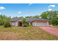 Charming single-story home with a well-maintained yard and attached two-car garage at 128 Oak Lake Dr, Spring Hill, FL 34608