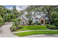 Charming two-story home with stone accents, lush landscaping, and a well-manicured lawn at 2880 Chelsea N Pl, Clearwater, FL 33759
