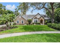 Charming stone and stucco home featuring manicured lawn and mature landscaping at 2880 Chelsea N Pl, Clearwater, FL 33759