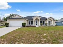 Single-story home with a well-manicured lawn and a two-car garage at 3312 Blythe Ave, Spring Hill, FL 34609