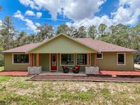 Charming single-story home with a cozy front porch and picturesque landscaping, perfect for relaxing outdoors at 34335 Berryhill Dr, Webster, FL 33597