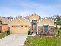 Charming single-story home features a manicured lawn, stone accents, and a two-car garage at 4266 High Ridge Ave, Spring Hill, FL 34609