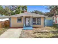 Charming single-story home featuring a blue and yellow color scheme and a well-manicured front lawn at 4503 Courtland St, Tampa, FL 33610