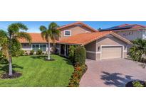 Beautiful single-story home with a paved driveway, lush green lawn, and tropical landscaping at 5145 Porpoise Pl, New Port Richey, FL 34652