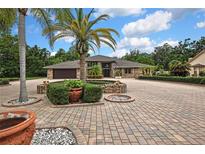 Stunning single-story home featuring a brick exterior and lush landscaping at 5747 Fieldspring Ave, New Port Richey, FL 34655