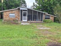 Cozy cottage home features stone accents and a screened porch for relaxed outdoor living at 7100 Ashwood Dr, Port Richey, FL 34668
