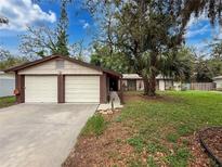 Charming single-story home with a spacious two-car garage and mature landscaping at 7119 Lenape Cir, New Port Richey, FL 34653