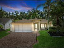 Charming single-story home with brick driveway, mature landscaping, and attached two-car garage at 8248 Sugarbush Dr, Spring Hill, FL 34606