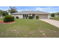 Charming single story home featuring a well-maintained lawn and screened garage at 8283 Shoup St, Spring Hill, FL 34606