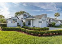 Beautiful single-Gathering home featuring manicured landscaping, a two-car garage, and a charming gated entrance at 1084 Vista Fina Ct, Spring Hill, FL 34608