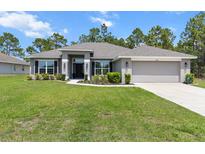 Charming one-story home with a well-manicured lawn and a two-car garage nestled among mature trees at 11042 Heth Ct, Weeki Wachee, FL 34613