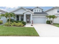 Charming single-Gathering home with a well-manicured lawn and inviting front entrance with beautiful landscaping at 15241 Caravan Ave, Odessa, FL 33556